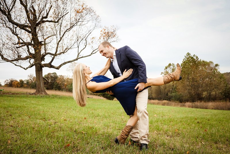 Engagement photography, a young man dips his fiance who has long blond hair. 
