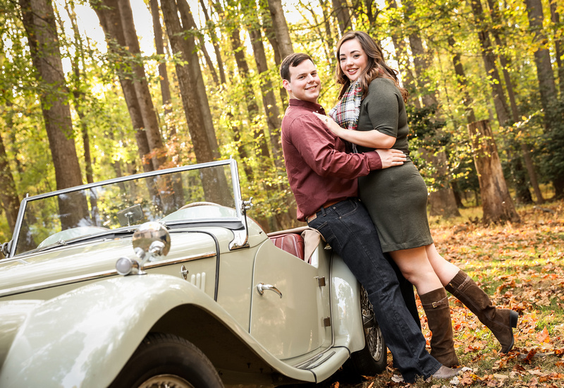 Engagement photography: two fiancées lean against an antique car and smile. 