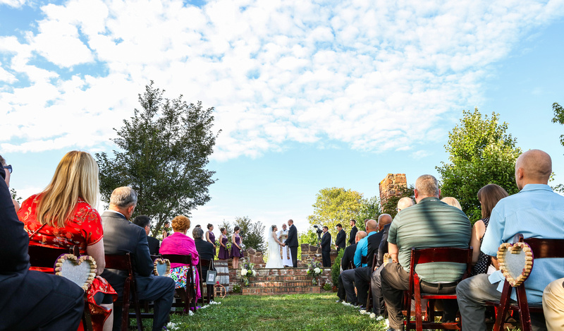 Wedding photography, blue skies looks over guests as they watch the wedding ceremony. 