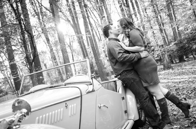 Engagement photography: two fiancées lean against an antique car and kiss. 