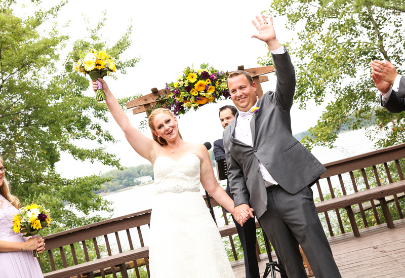 Wedding photography, the bride and groom wave to their loved ones after the ceremony. 