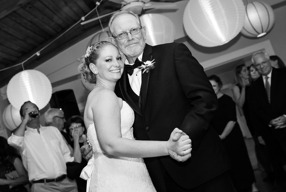 Wedding photography, the bride dances with her father in a black tuxedo. 