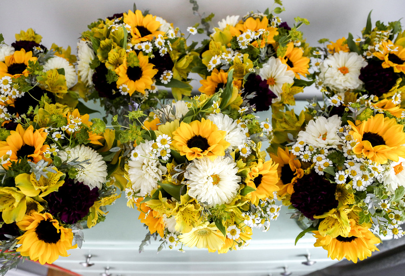 Wedding photography, multiple bouquets of bright yellow sunflowers and white daisies. 