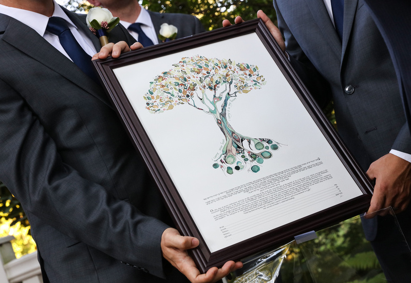 Wedding photography, three groomsmen hold the ketubah, a beautiful watercolor tree. 
