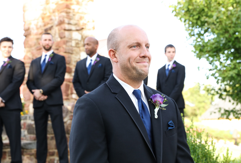 Wedding photography, a groom fights back tears as he watches his bride walk down the aisle. 