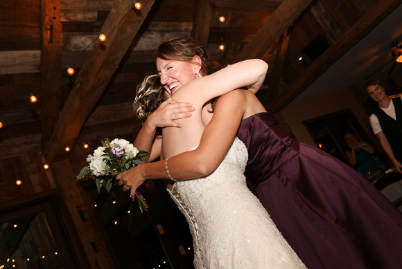 Wedding photography, the bride hugs the catcher of the bouquet, who is smiling. 