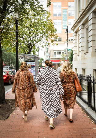 Wedding photography, a bride and bridesmaids walk down the DC streets wearing animal print robes. 