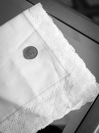 Wedding photography, a two pence piece on a white handkerchief. 