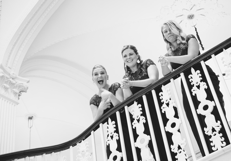 Wedding photography, bridesmaids smile and laugh on a staircase. 