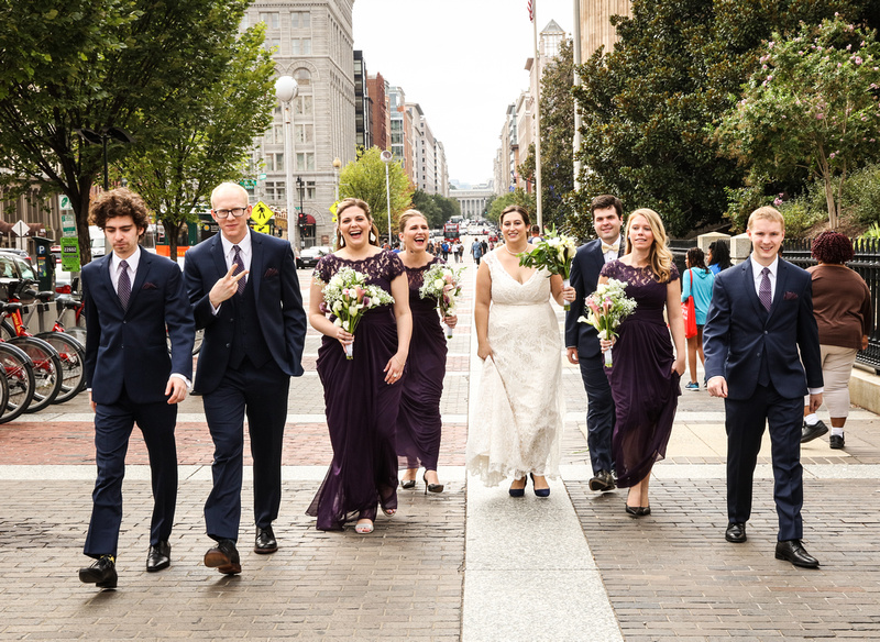 Wedding photography, a wedding party laughs while walking through the DC streets. 