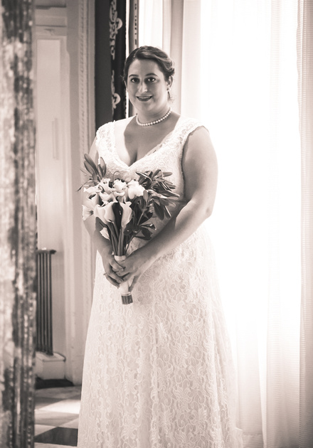 Wedding photography, a bride in a lace gown holding white tulips. 
