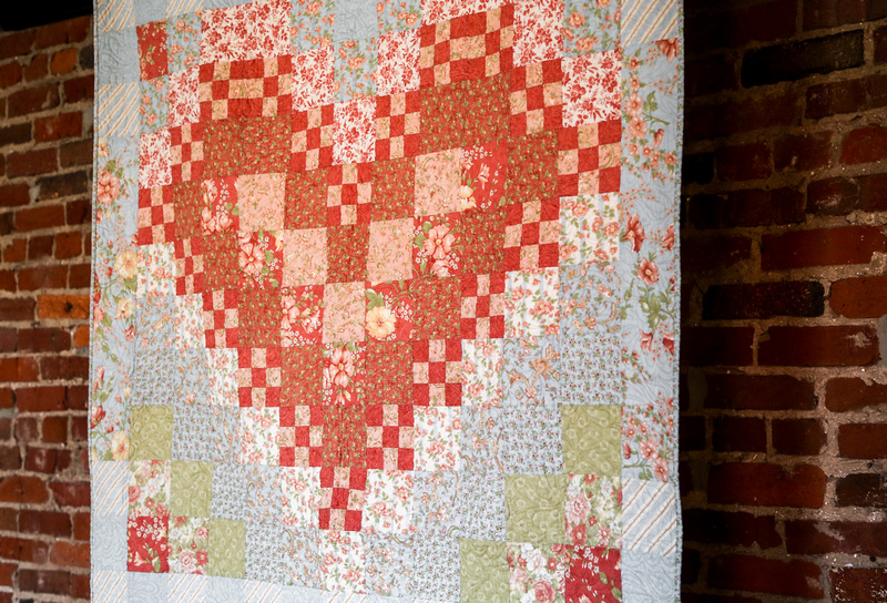 Wedding photography, a wedding quilt with blue patches and a red floral heart. 