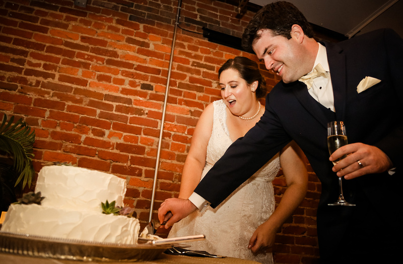 Wedding photography, a bride and groom cut their cake. 