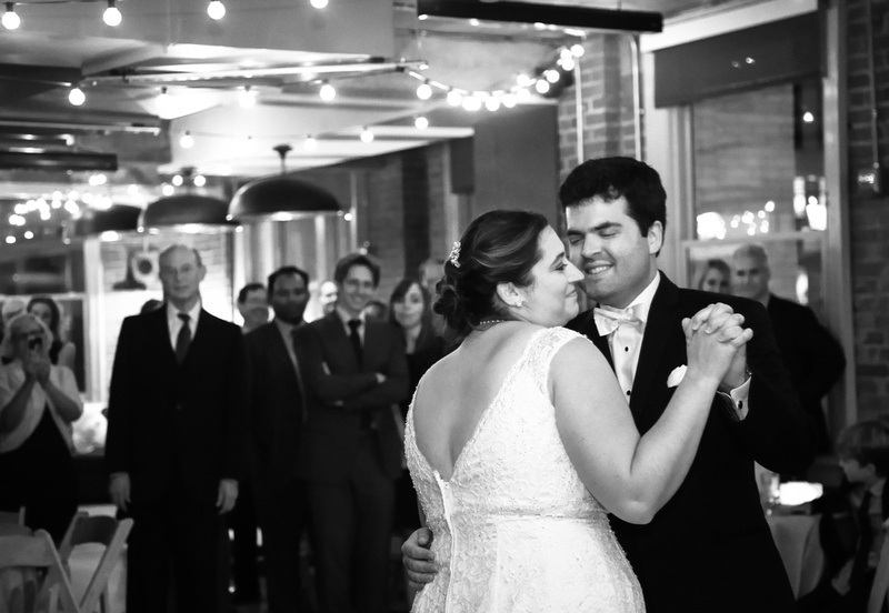 Wedding photography, a bride and groom smile while sharing their first dance. 