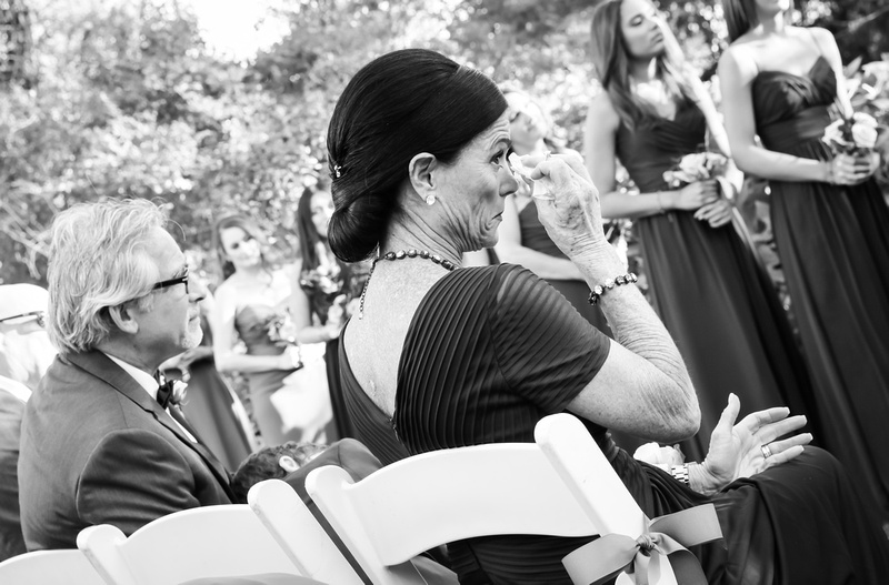 Wedding photography, the mother of the bride wipes away tears of joy during the ceremony. 