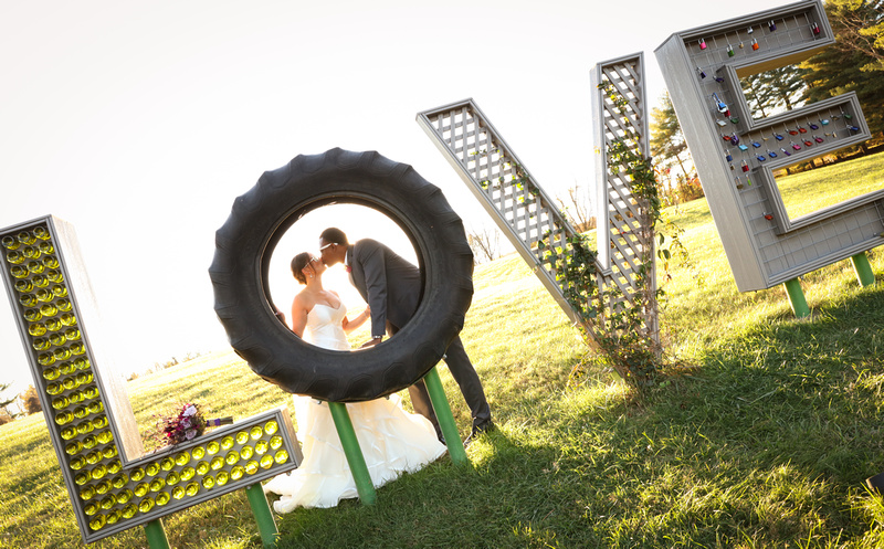 Wedding photography, a bride and groom kiss inside the O of a LOVE sculpture. 