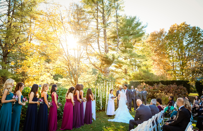Wedding photography, bright sunshine coming through the yellow trees during a wedding ceremony. 