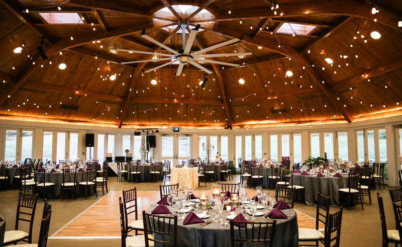 Wedding photography, the reception hall with a gorgeous wooden ceiling and string lights. 