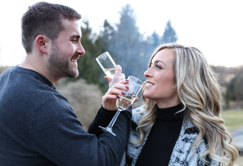 Engagement photography, a couple crosses arms and share a sip of champagne. 