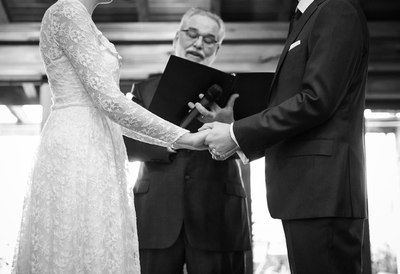 Wedding photography, a closeup of a couple holding hands during their wedding ceremony. 