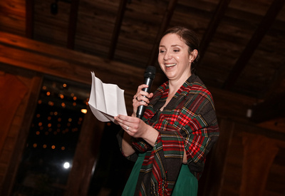 Wedding photography, the maid of honor delivers her speech wearing a red plaid shawl. 