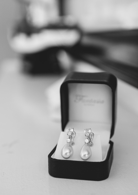 Wedding photography, teardrop diamond earrings in a black jewelry box. 