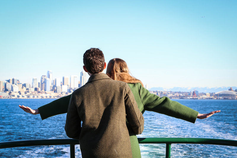Wedding photography, a woman in a green coat imitates Titanic with her fiancé. 