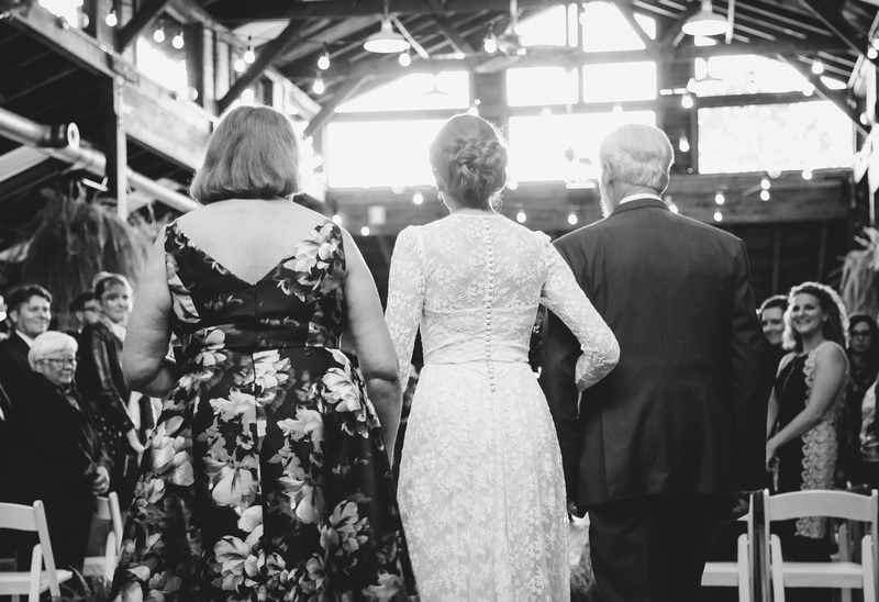 Wedding photography, a bride walking down the aisle with her parents. 