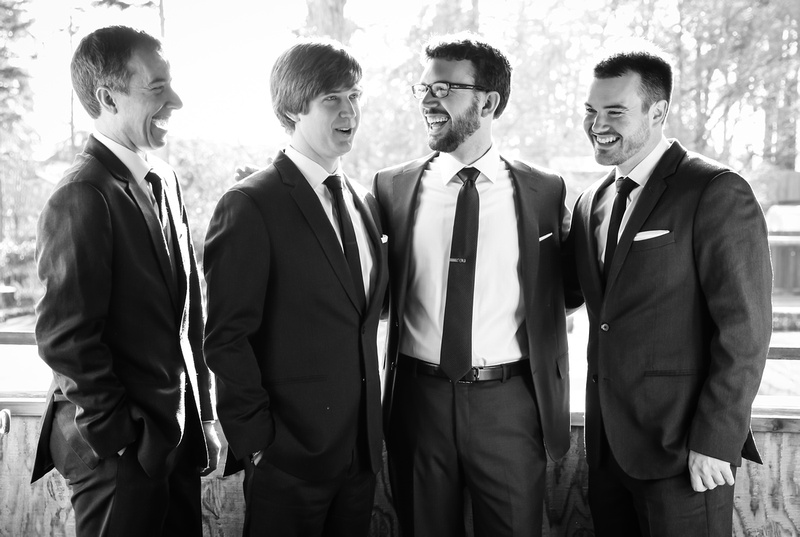 Wedding photography, a groom and his groomsmen are laughing hard. 