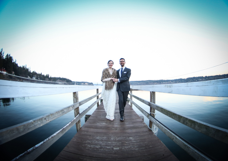 Wedding photography, a fisheye shot of a couple walking down a dock towards the camera. 