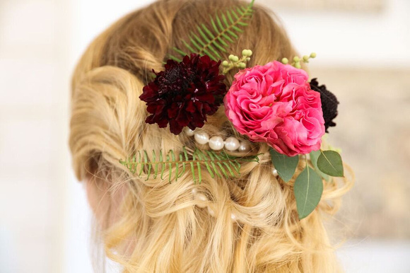 Bride wearing decorative, floral hair piece at the back of her head. Pink, marroon flowers, pearls and leaves. Designed by Flower Haus Guys