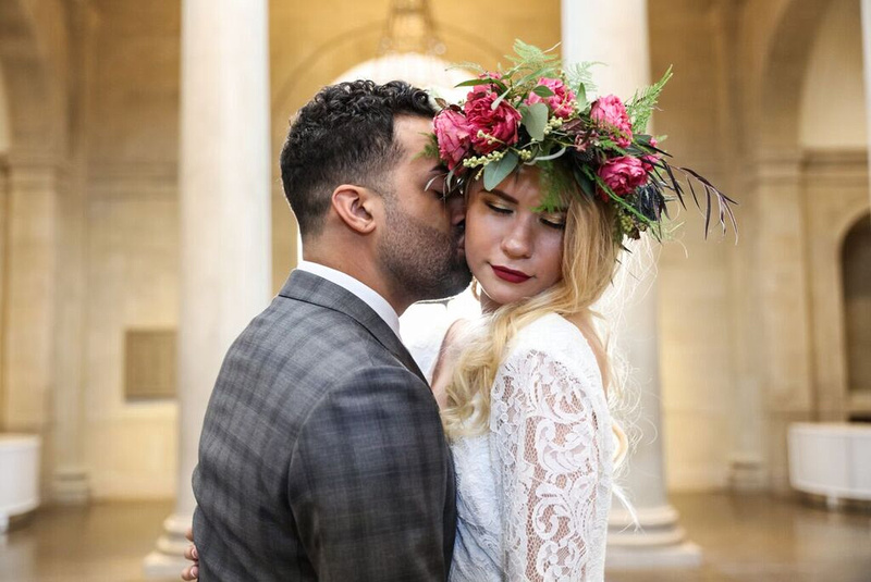 Groom kisses the check of bride, who wears floral crown at the baltimore museum of art. Styled wedding shoot by photos by kintz.
