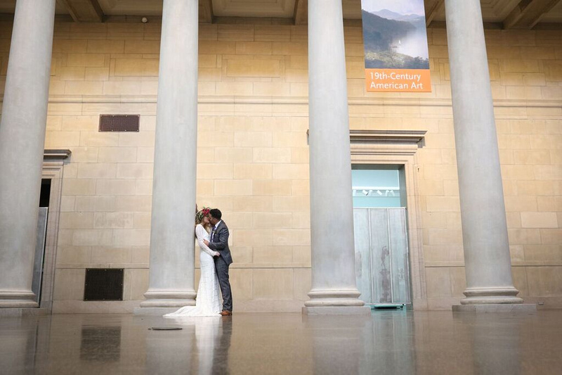 Bride and groom kiss as bride leans against a giant while marble column in a large open gallery at the baltimore museum of art. Styled wedding shoot by photos by kintz