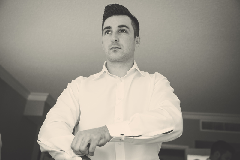 Wedding photography, a handsome young man putting on a white dress shirt. 