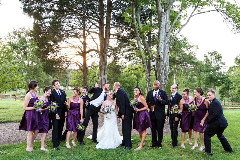 Wedding photography, a wedding party gets silly standing in front of tall trees. 
