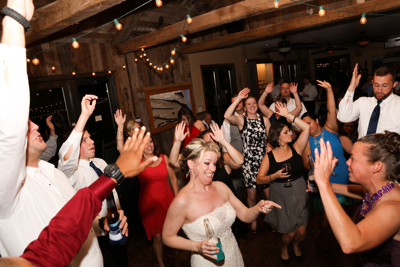Wedding photography, the bride is laughing on the dance floor, surrounded by happy partiers. 