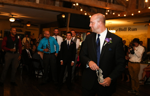 Wedding photography, the groom looks back at his men before tossing the garter. 