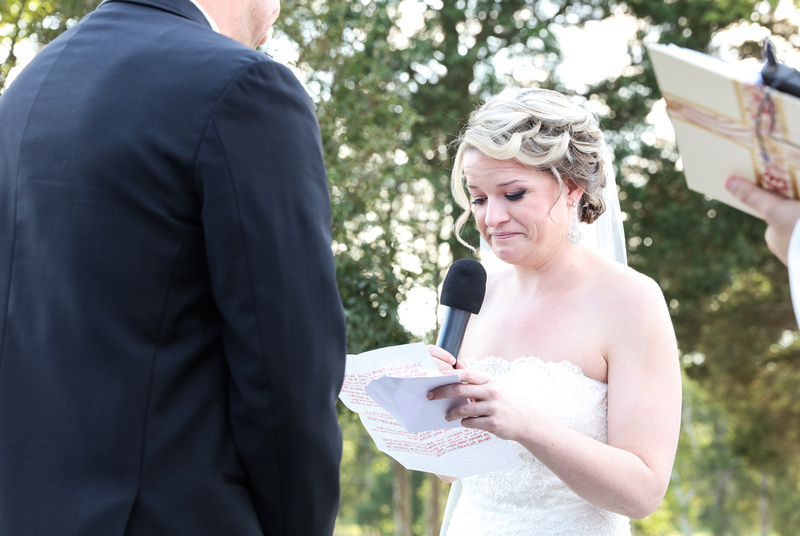 Wedding photography, a bride fights back tears as she reads her wedding vows. 