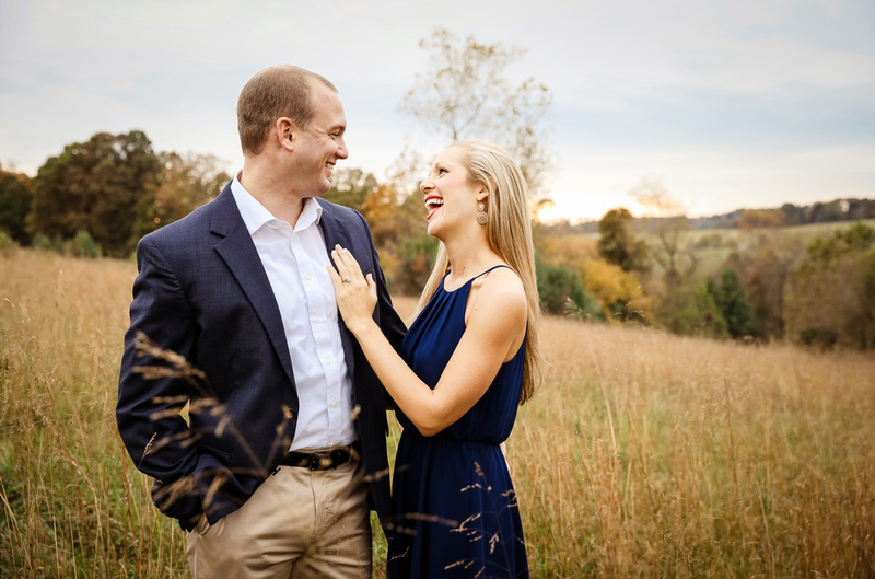 Engagement photography, a young lady laughs with love as she places her hand on her fiance's chest. 