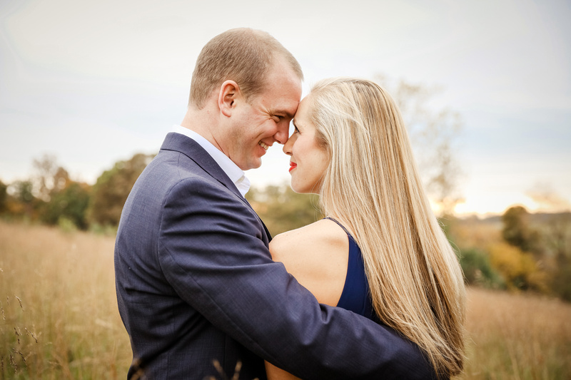 Engagement photography, a young couple place their foreheads together and smile lovingly. 