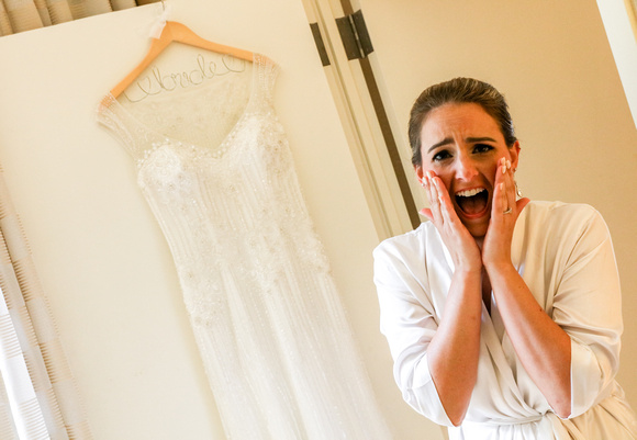 Wedding photography, a bride screams with disbelief and excitement before putting on her wedding dress. 