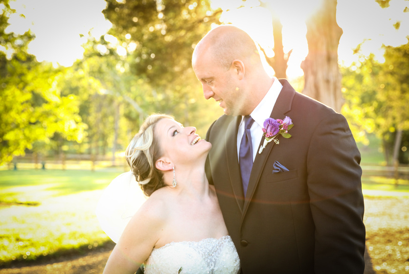 Wedding photography, a bride and groom gaze upon each other as the sun shines behind them. 