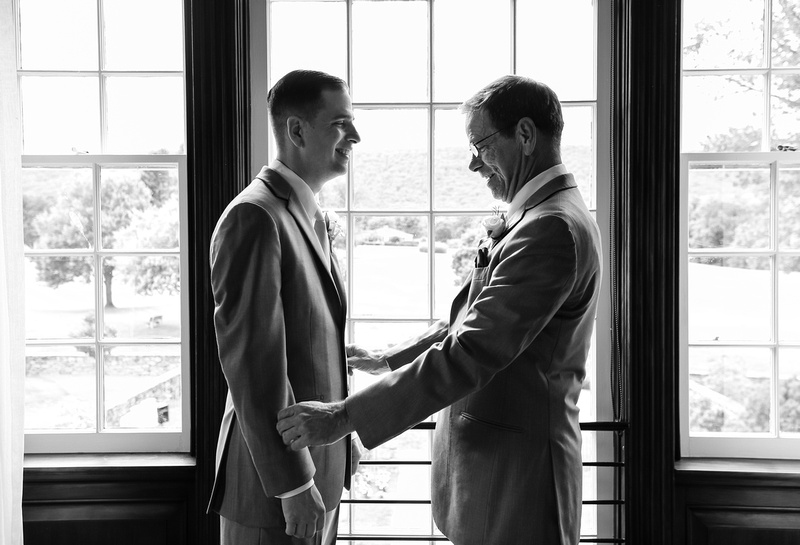 Wedding photography, a father lovingly looks at his smiling son, the groom, just before the wedding ceremony. 