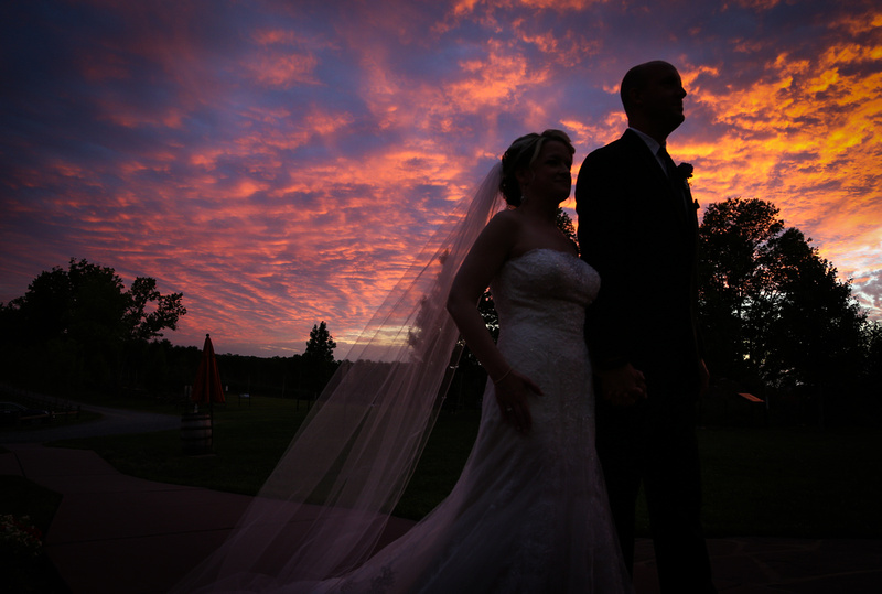 Wedding photography, a bride and groom enter their reception in silhouette with a gorgeous sunset behind them.  