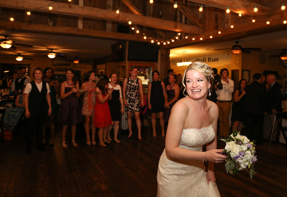 Wedding photography, a bride smiles playfully just before she tosses her bouquet. 