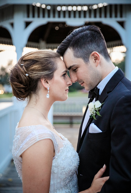 Wedding photography, a bride and groom place their foreheads together lovingly. 